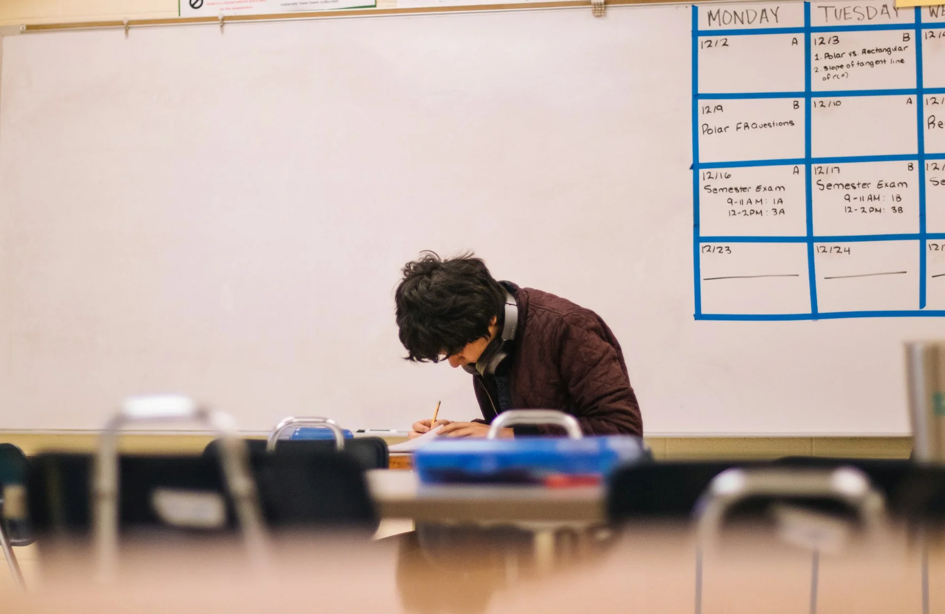 photo - a SEND student sitting in a school classroom working on his homework 