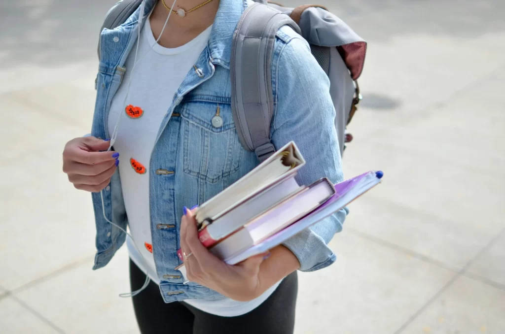 photo - a girl holding books and considering Alternative to gcse for sen children