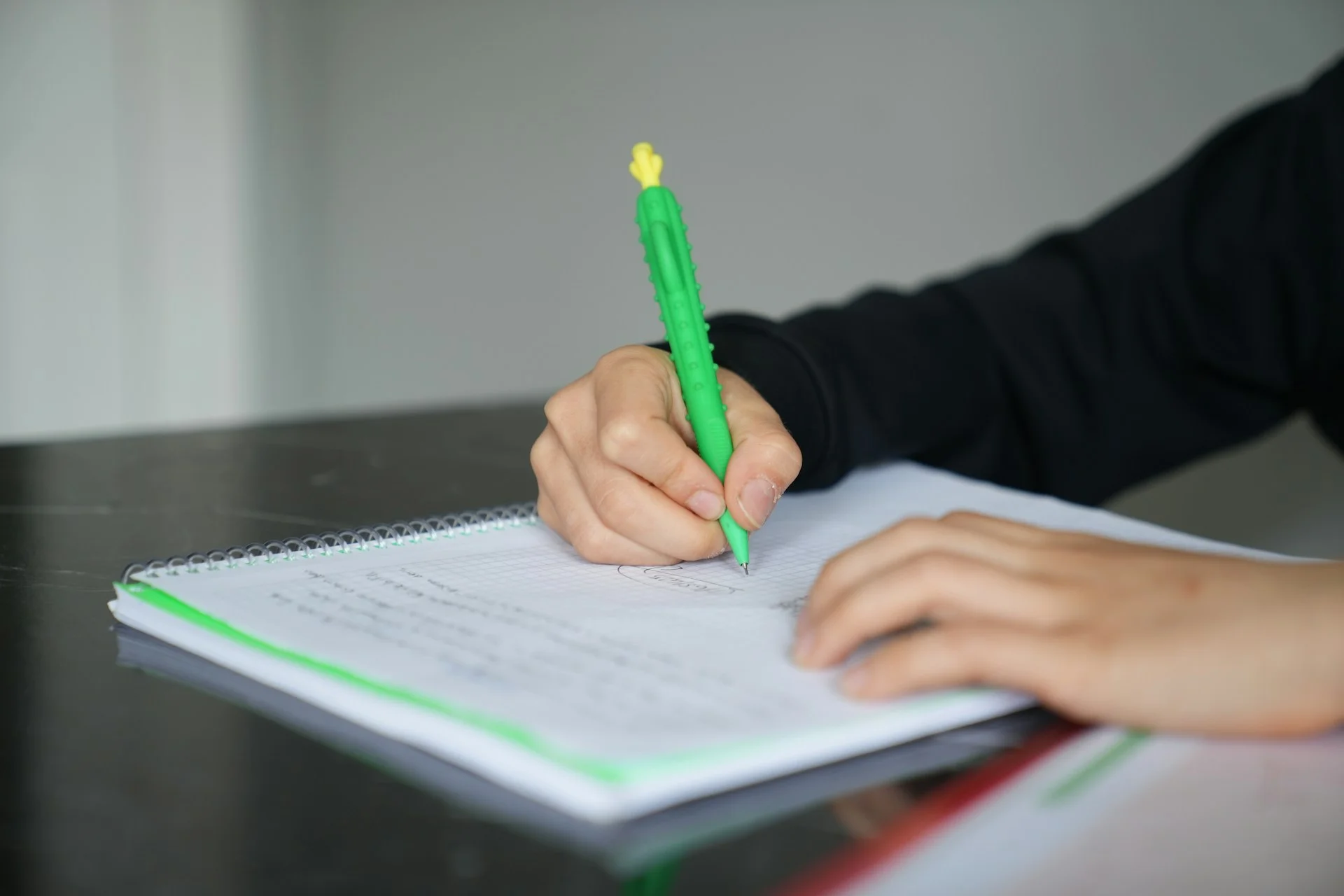 photo - a piece of paper and a child's hand writing on it. how to take gcse exams at home