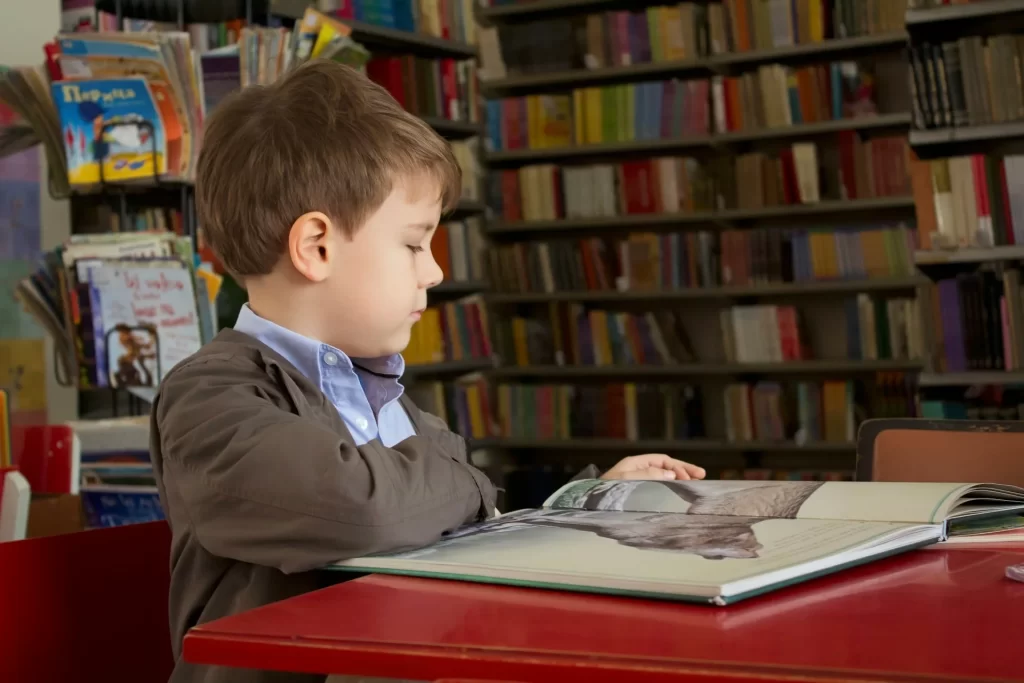 photo - a boy sitting in the library trying to learn. Discover the key difference between learning disability and learning difficulty and how tailored support for SEN(D) students can enhance their learning experience