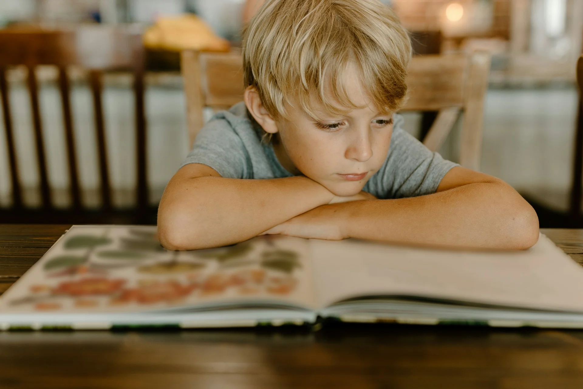 photo - a boy with arfid and autism reading a book in his living room