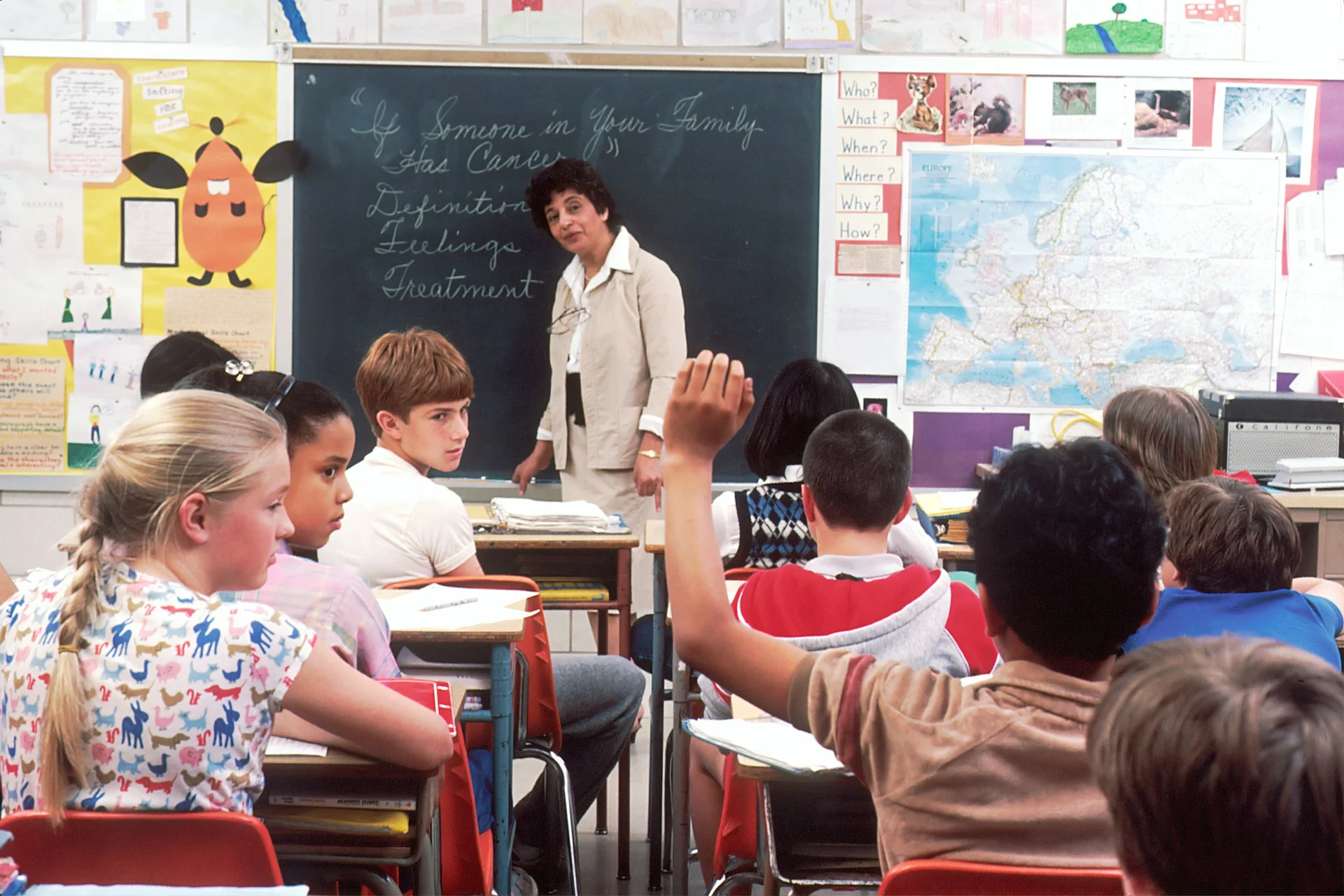 photo - a child raising his hand in a sen school classroom