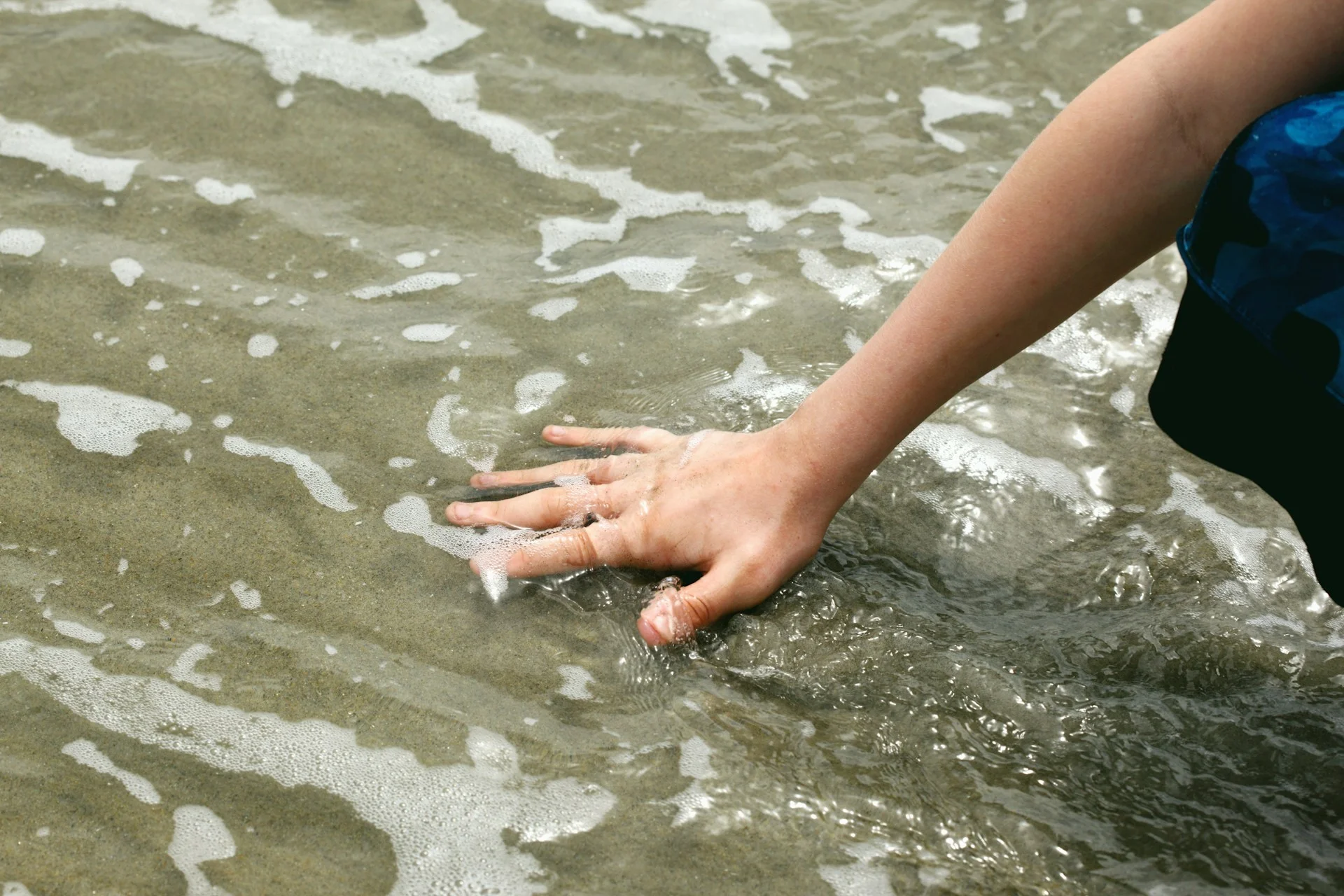 photo - a child touching water during sensory therapy