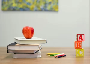 photo - books, cubes, pencils and an apple on a table in a classroom for sensory education 