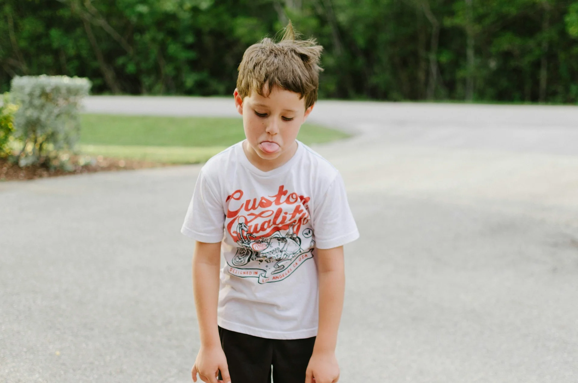 photo - an upset boy sticking his tongue out in an act of social emotional and mental health distress adhd