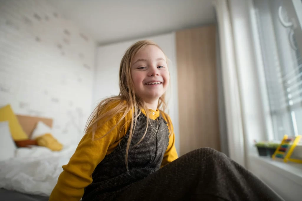 photo - a laughing girl in her room with a special educational needs statement