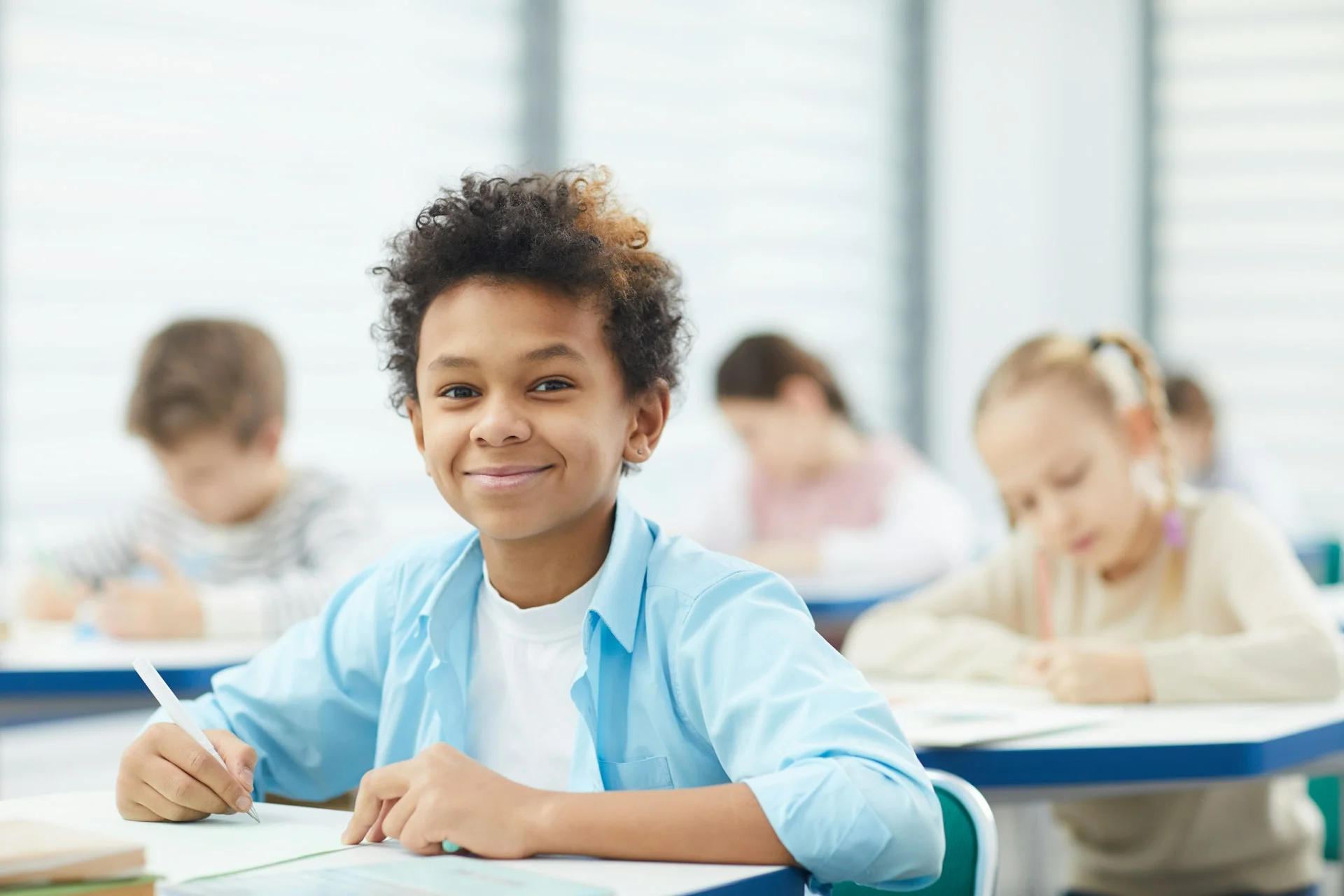 photo - a smiling boy looking at the camera in a classroom on sen register benefits