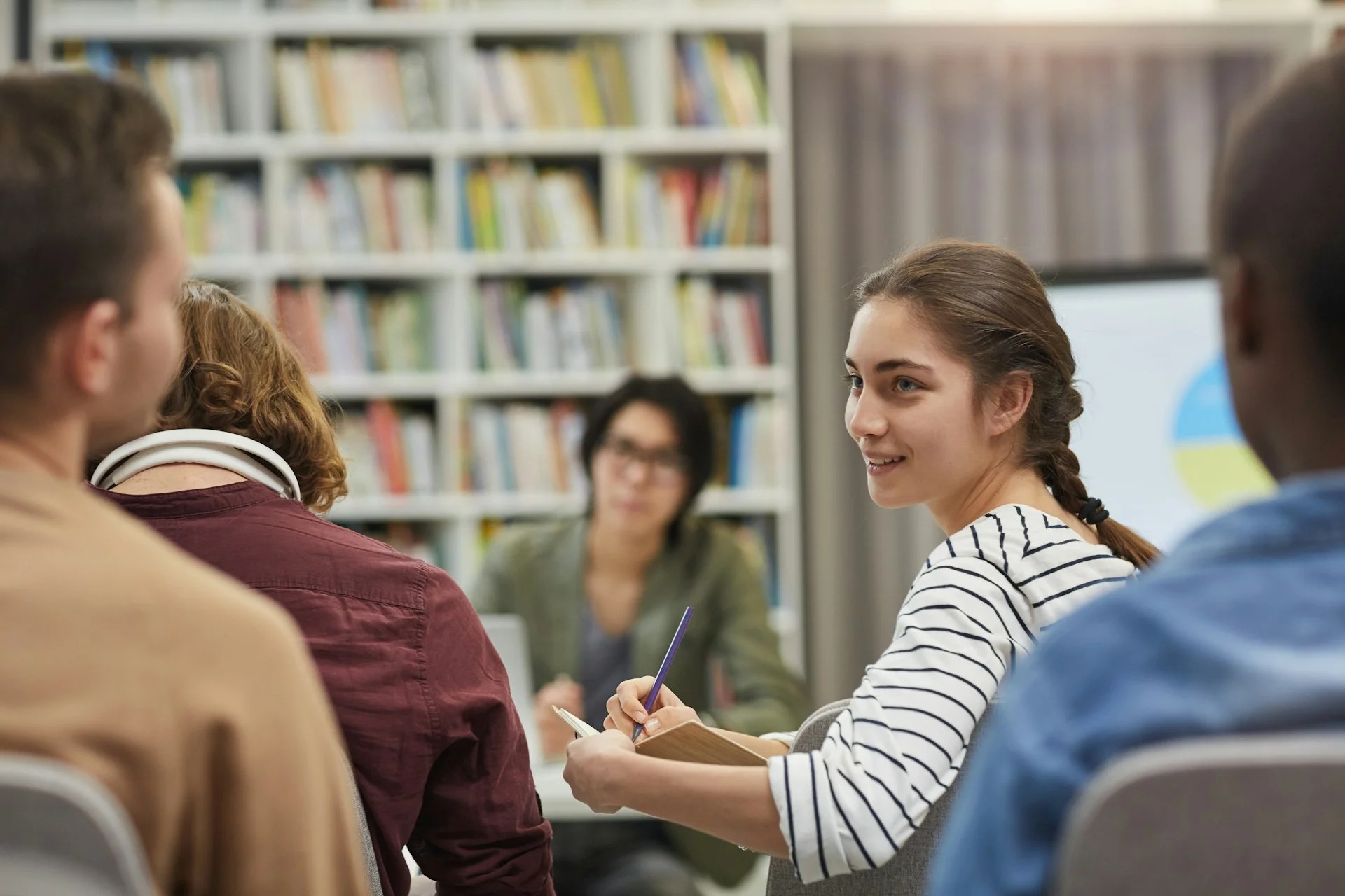 photo - a student with sen in a UK classroom chatting with her classmates