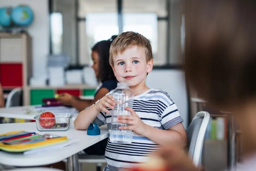 photo - a boy drinking water in his school classroom under sen law