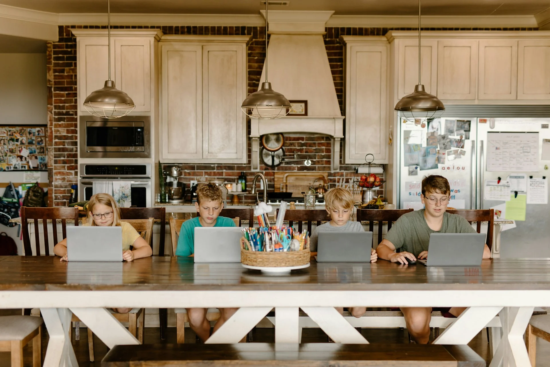 photo - four children are doing homework as per their  homeschooling syllabus uk