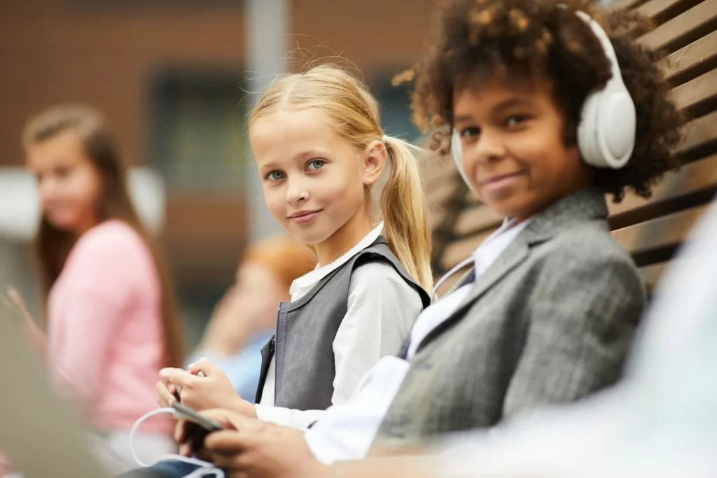 photo - two students looking at the camera, one of them on send register