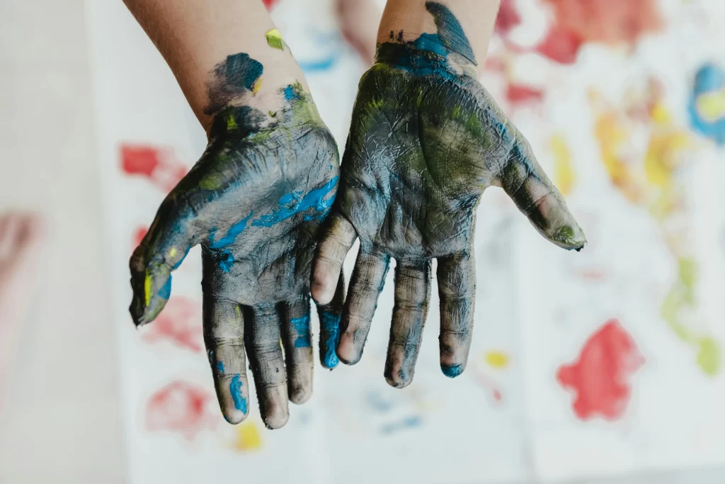 Photo - Children’s hands covered in paint from hands-on activities incorporating SEN in schools.