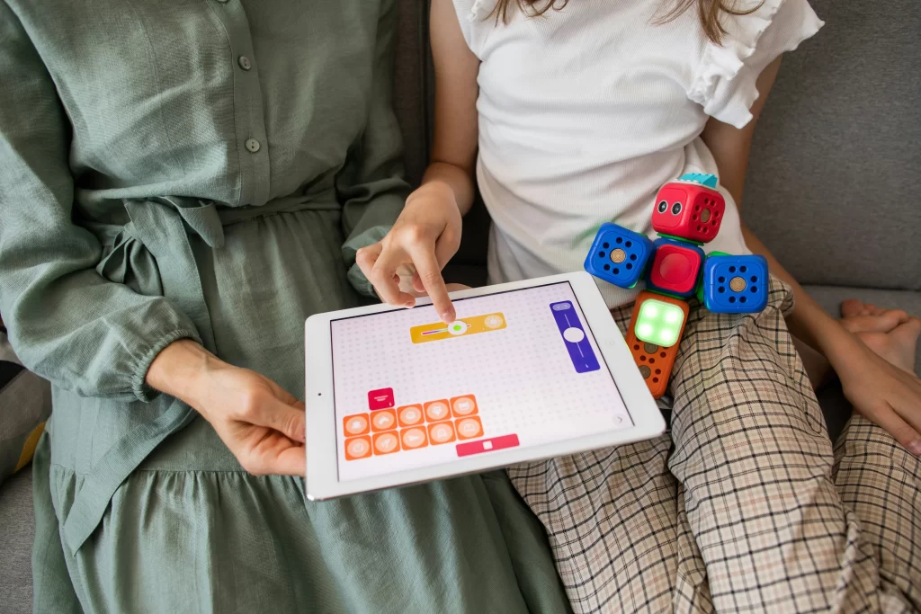 Photo - Girl using iPad with a tutor for inclusive learning in specialised schools representing what is a SEN school and SEN support.