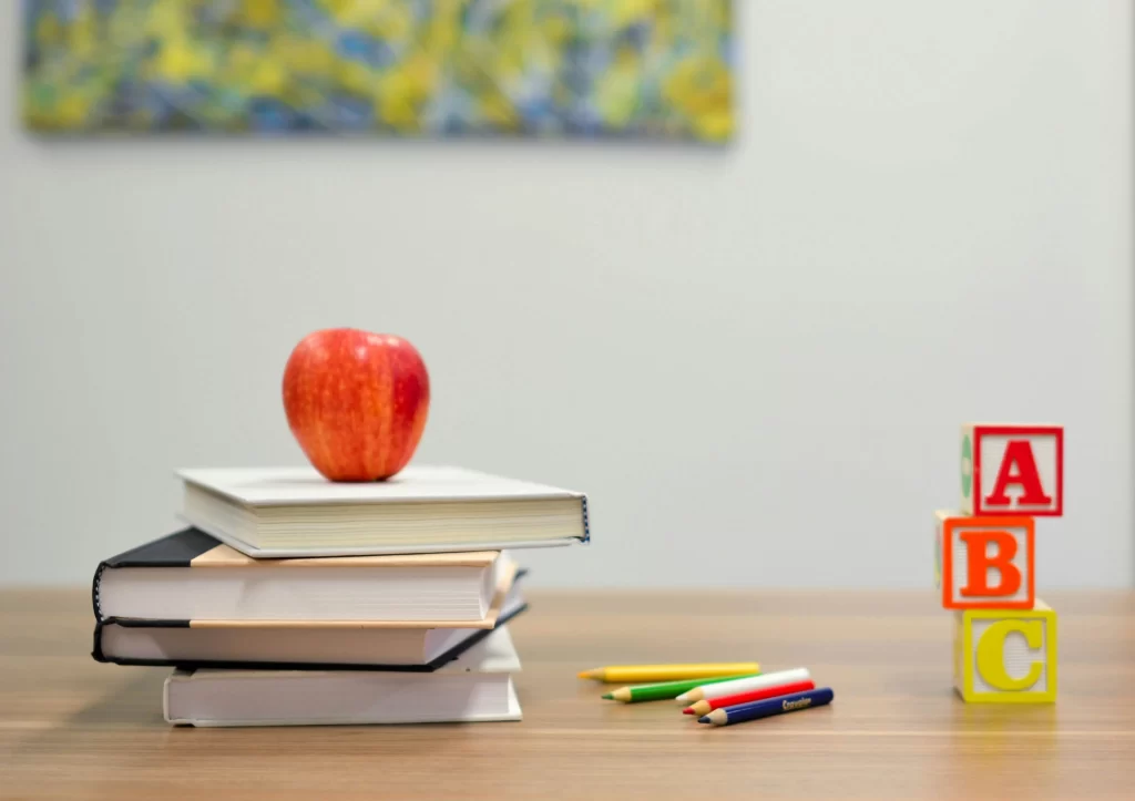 Photo - desk with apple, book and learning supplies on it symbolizing inclusive learning in schools in Borehamwood