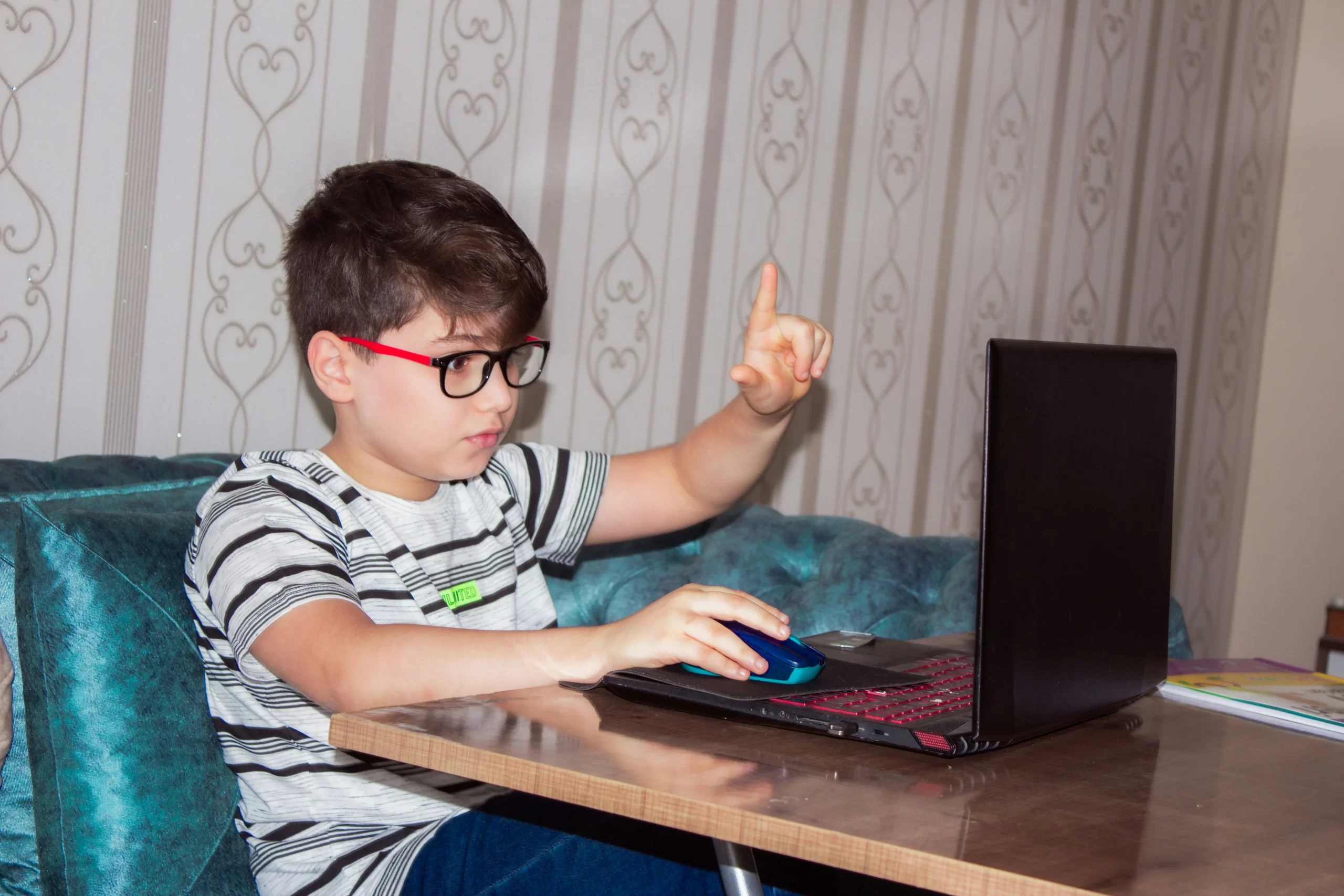 photo - a Little boy with dyspraxia and handwriting using a computer for assistive technology.