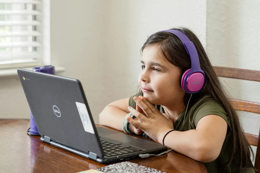 photo - Girl with childhood dyspraxia looking at a computer used for assistive technology