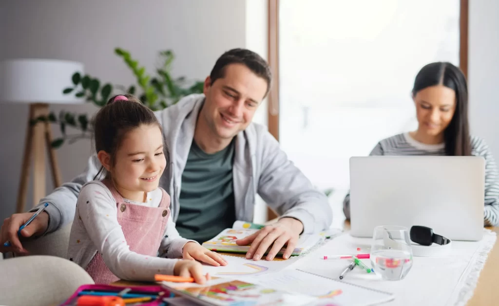 photo - two parents and a child sitting at a table after learning what is semh needs helping their child with homework