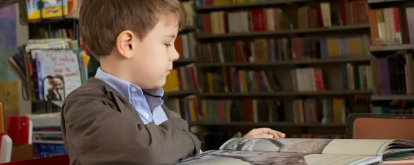 photo - a boy sitting in the library trying to learn. Discover the key difference between learning disability and learning difficulty and how tailored support for SEN(D) students can enhance their learning experience