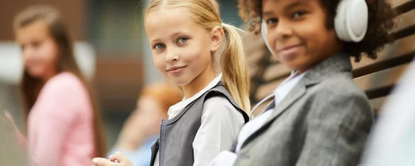 photo - two students looking at the camera, one of them on send register