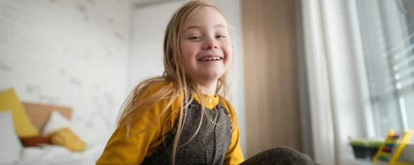 photo - a laughing girl in her room with a special educational needs statement