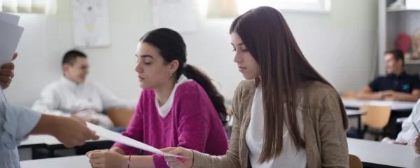 photo - two girls sitting in a classroom wondering "can you resit a levels"?