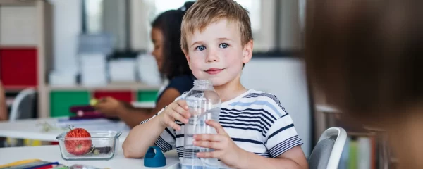 photo - a boy drinking water in his school classroom under sen law