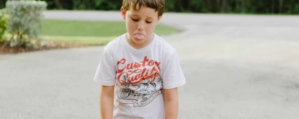 photo - a sad boy with EHCP for ADHD is walking away from a park