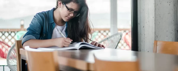 photo - an autistic girl sitting at a table studying for her Maths gcse tutor GCSE tuition session